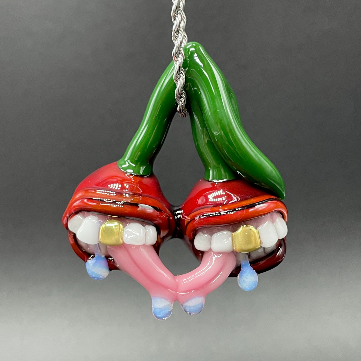 Cherry Lover handblown glass pendant - paired red cherries with green stem, each with open grinning mouth, white teeth, gold tooth, pink tongues, silver rope chain - Leviathan Glass