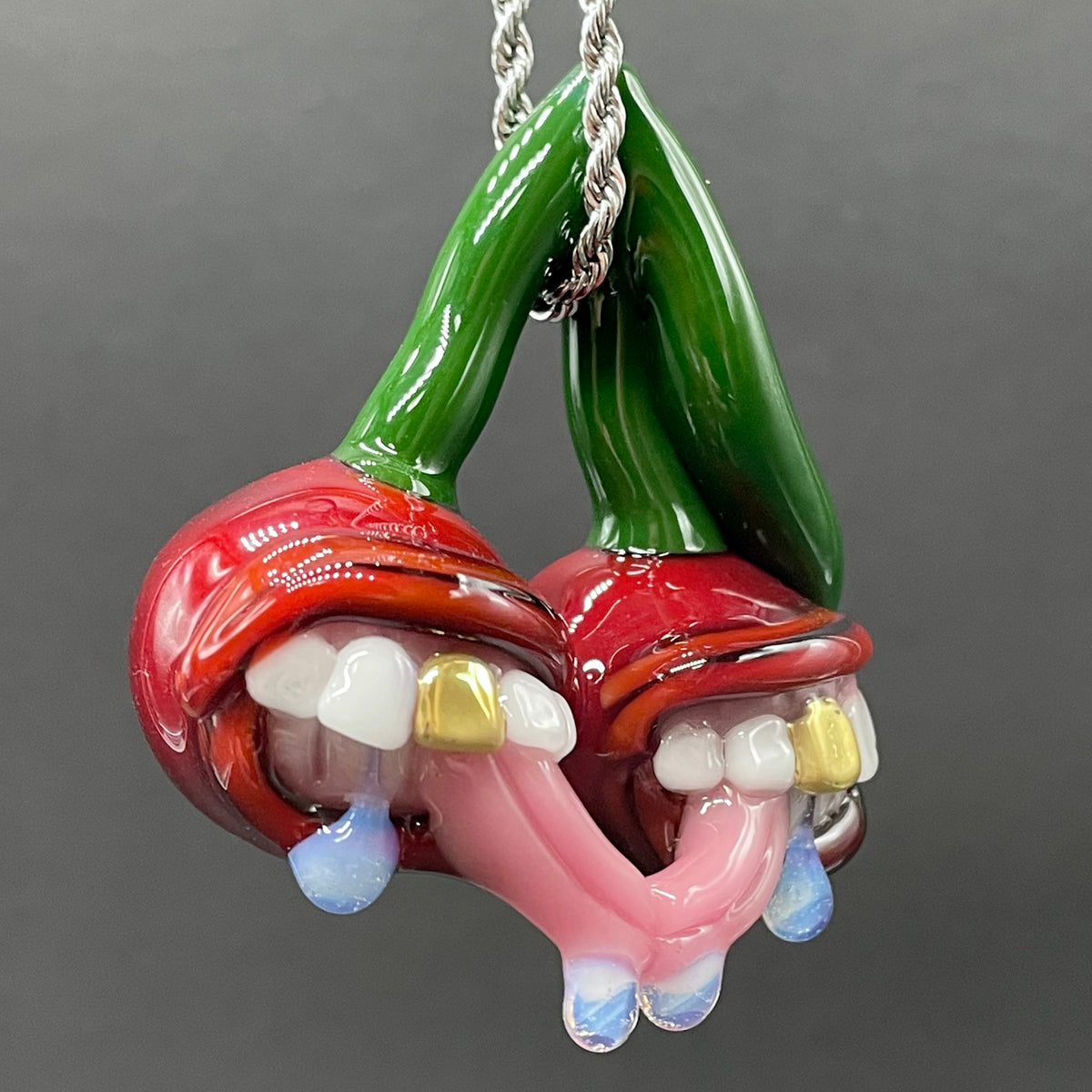Cherry Lover handblown glass pendant - paired red cherries with green stem, each with open grinning mouth, white teeth, gold tooth, pink tongues, silver rope chain - Leviathan Glass