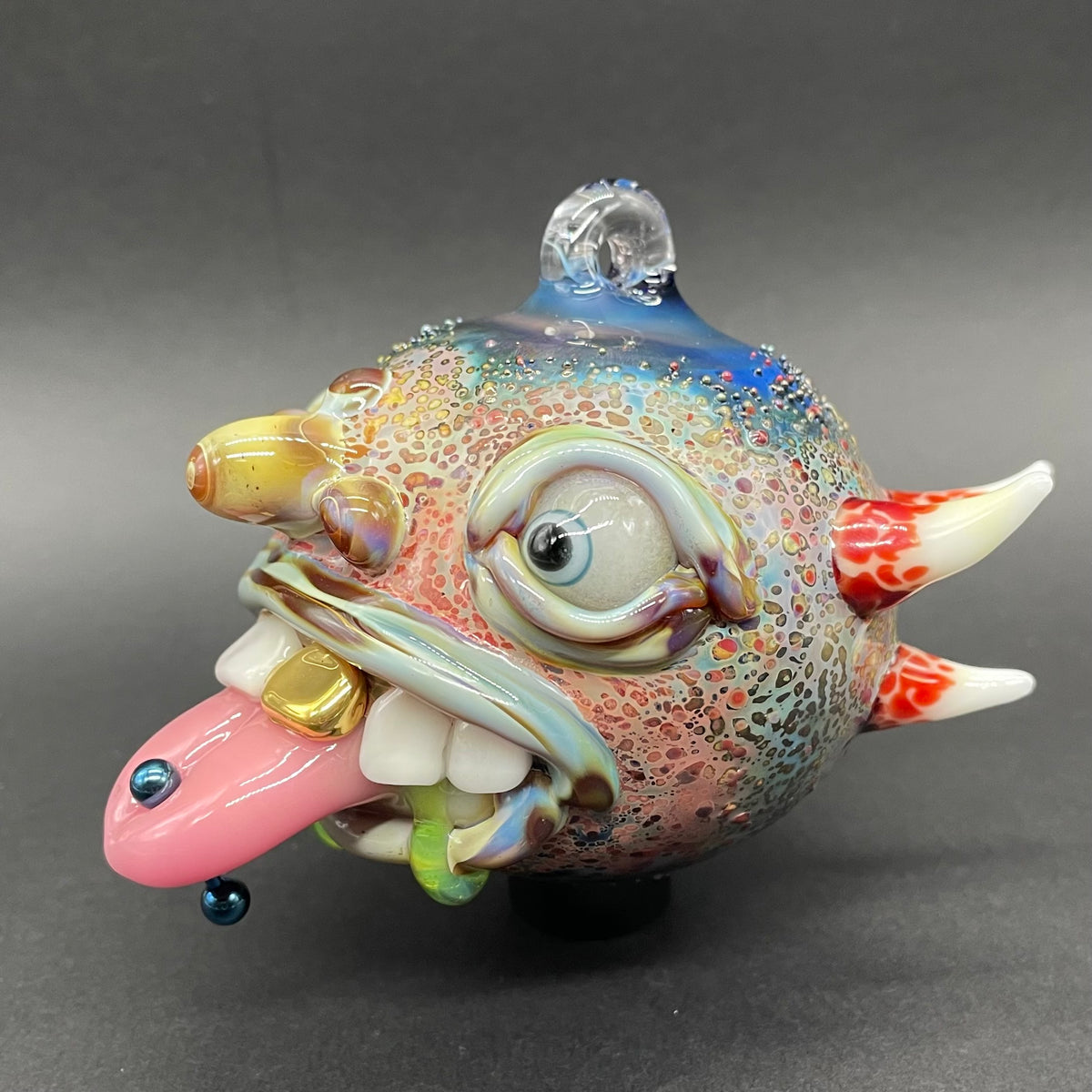 Close-up of Pierced tongue cyclops ornament - handcrafted glass
