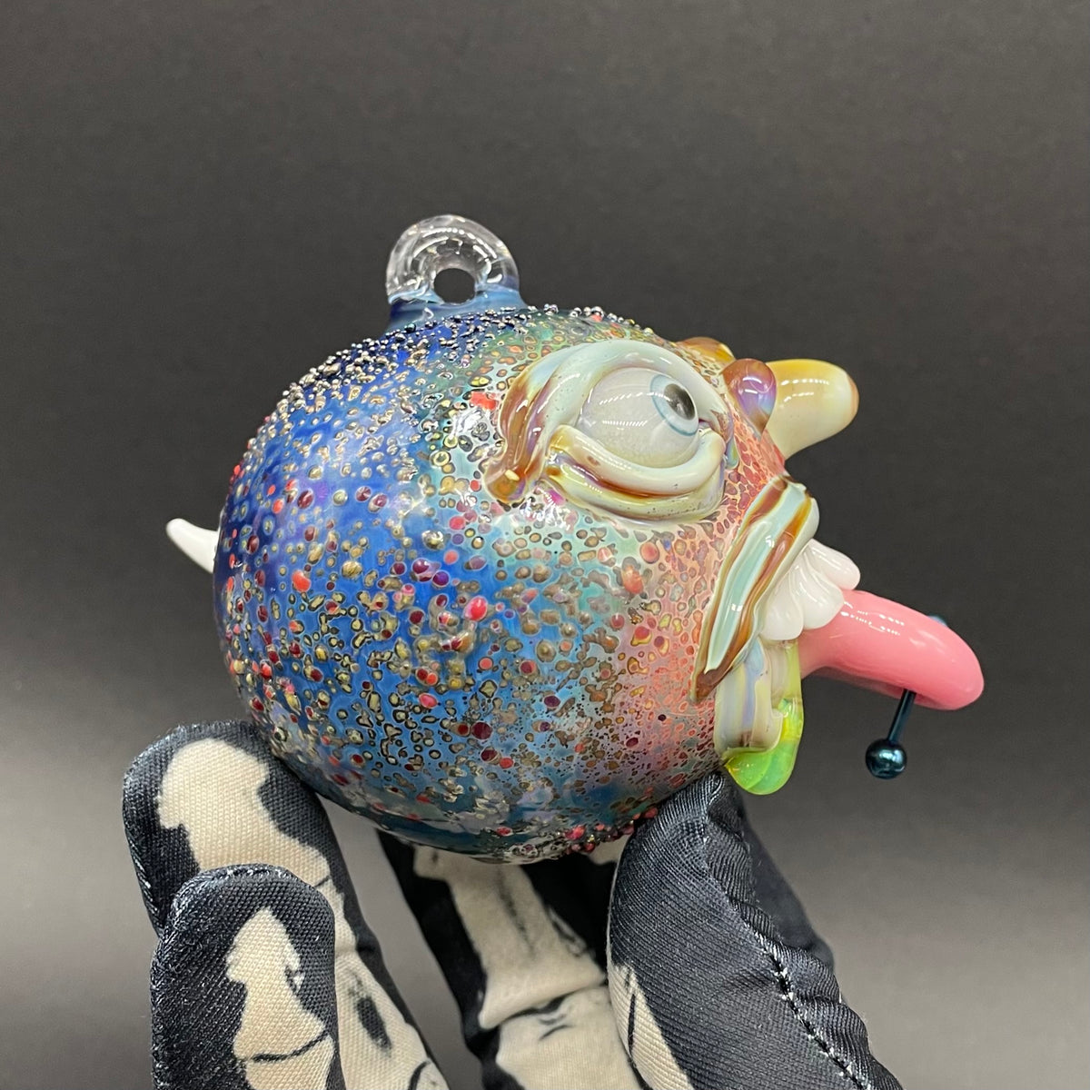 Close-up of Pierced tongue cyclops ornament - handcrafted glass