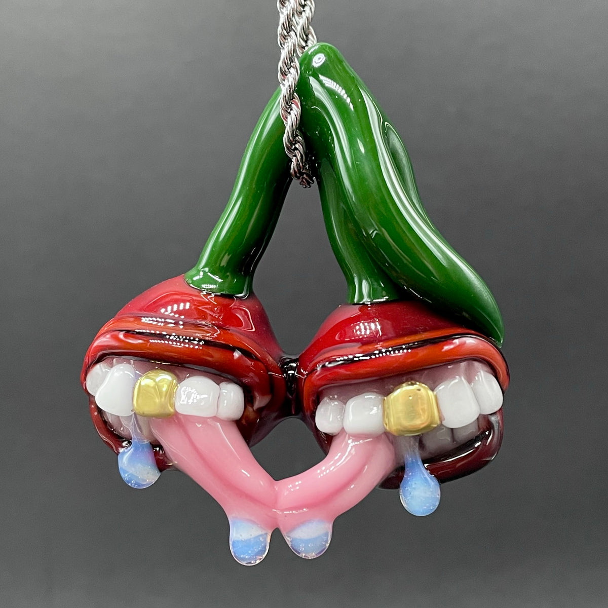 Cherry Lover handblown glass pendant - paired red cherries with green stem, each with open grinning mouth, white teeth, gold tooth, pink tongues, silver rope chain - Leviathan Glass