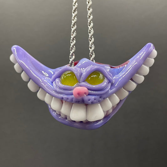 Grinning Cheshire cat glass pendant