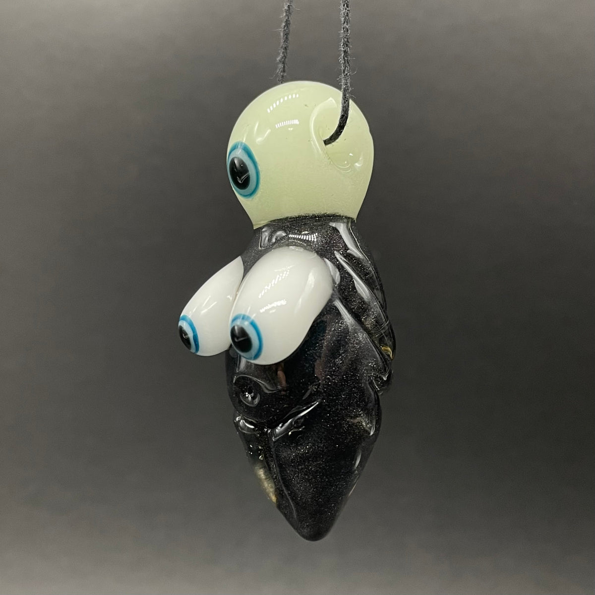 Close-up of Black light reactive fertility pendant - handcrafted glass