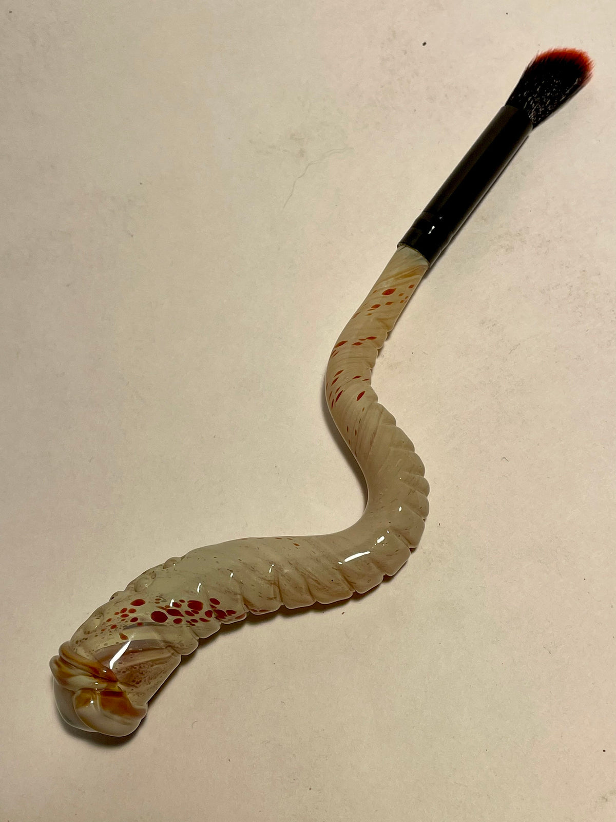 Glass makeup brush with glow in the dark eye and carved ventral scales. craftsmanship - artisan glass work