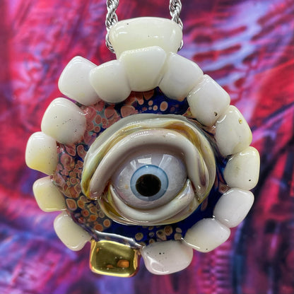 Unidentified Object Delta handblown glass pendant - circular disc ringed with ivory teeth, blue iris eye center, eyelid, gold tooth accent, silver rope chain - Leviathan Glass
