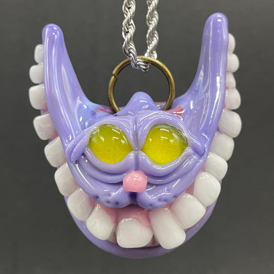 Grinning Cheshire cat glass pendant