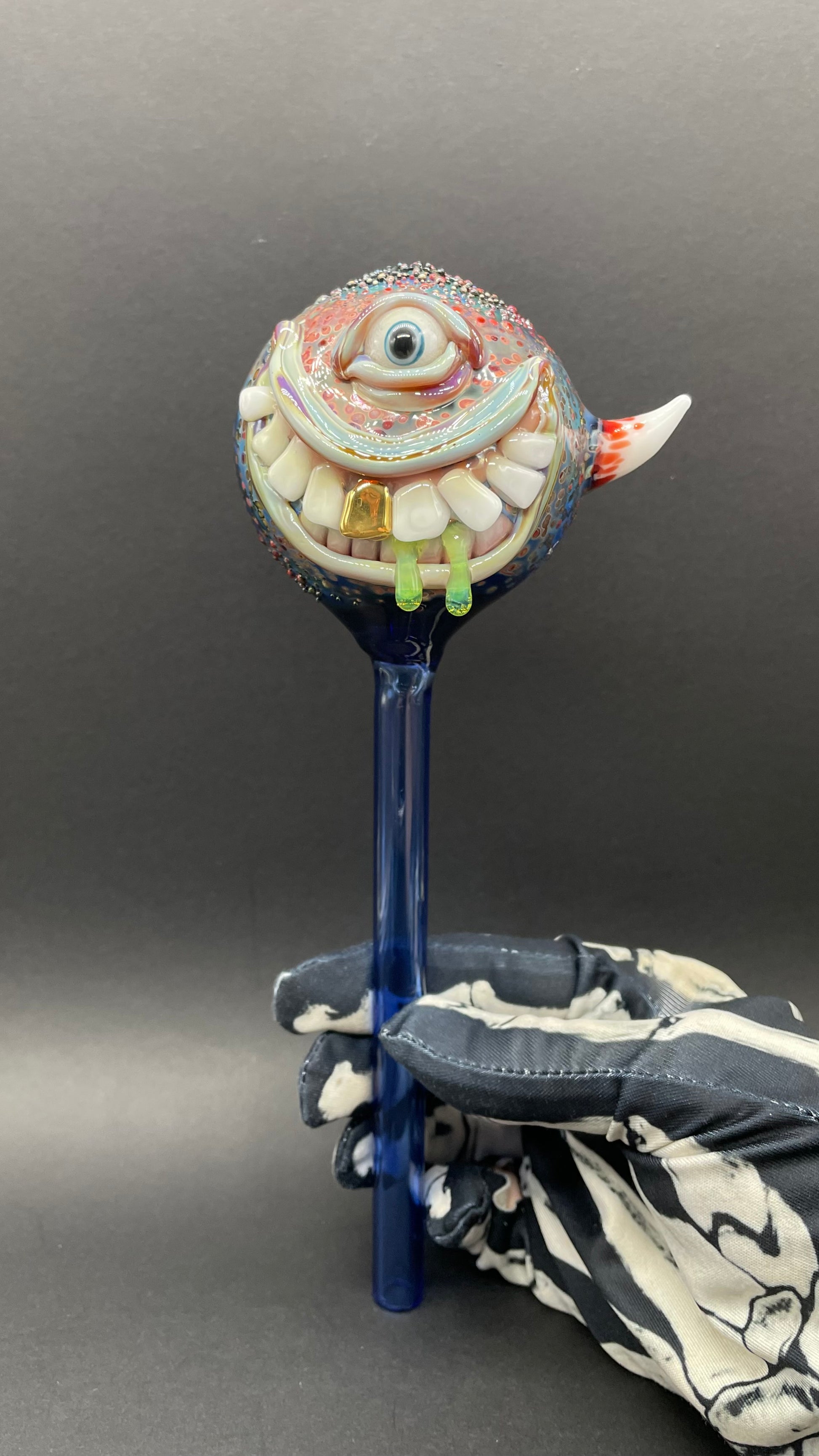 Hand Blown Glass Monster Watering Globe - round cyclops head, blue iris eye, white teeth, gold tooth, teal tongue drips, teal glass stake - Leviathan Glass