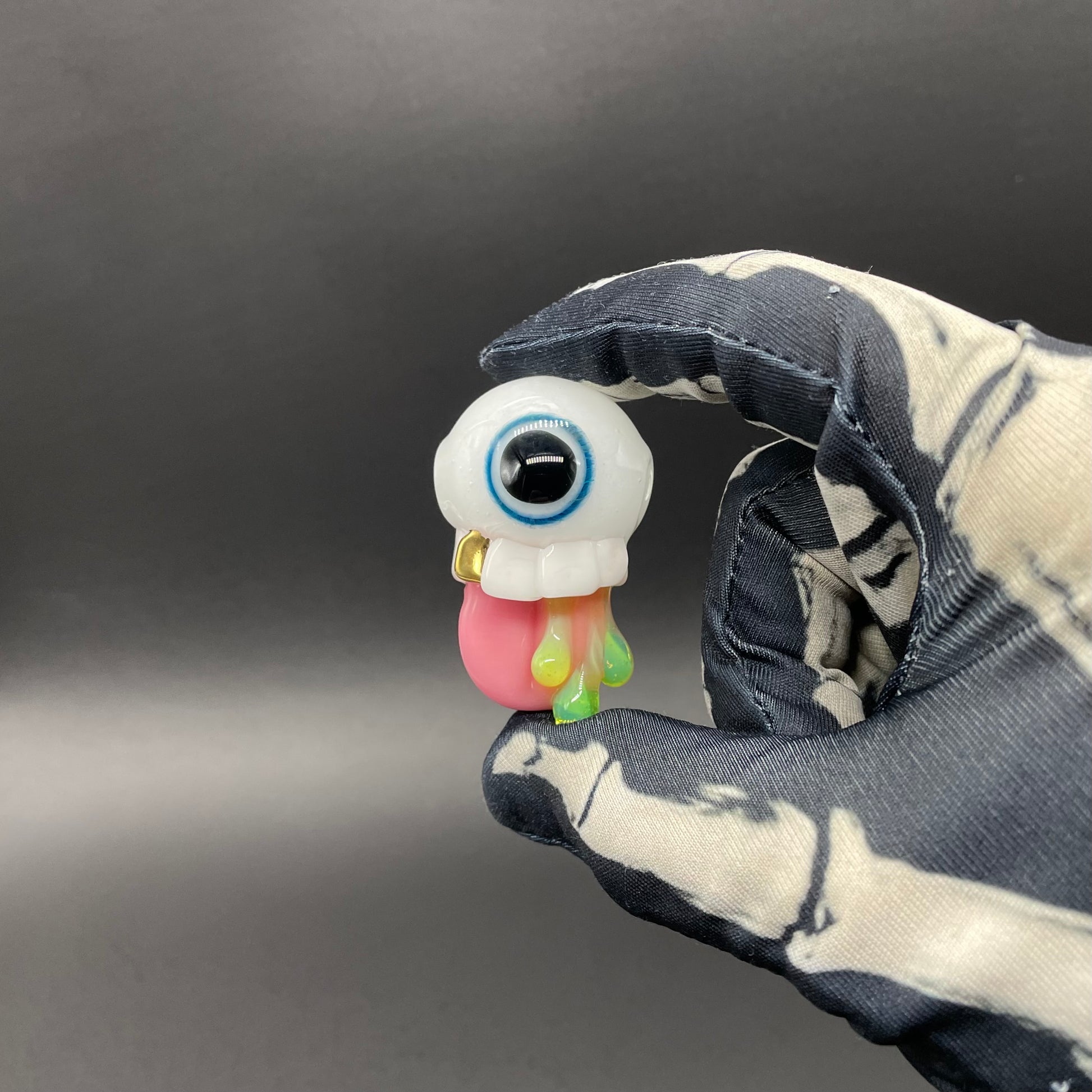 Close-up of Glow in the dark eye pendant - handcrafted glass