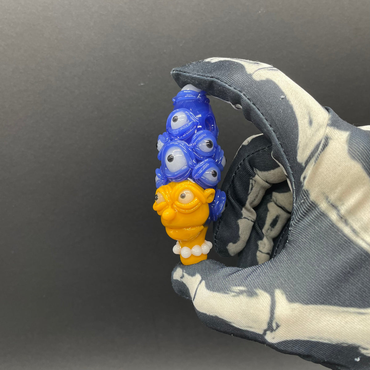 Marge Simpson Mutant handblown glass pendant - yellow Marge Simpson face with towering stack of blue cyclops creatures forming her hair, white pearl beads, silver rope chain - Leviathan Glass