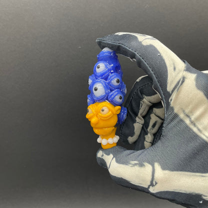 Marge Simpson Mutant handblown glass pendant - yellow Marge Simpson face with towering stack of blue cyclops creatures forming her hair, white pearl beads, silver rope chain - Leviathan Glass