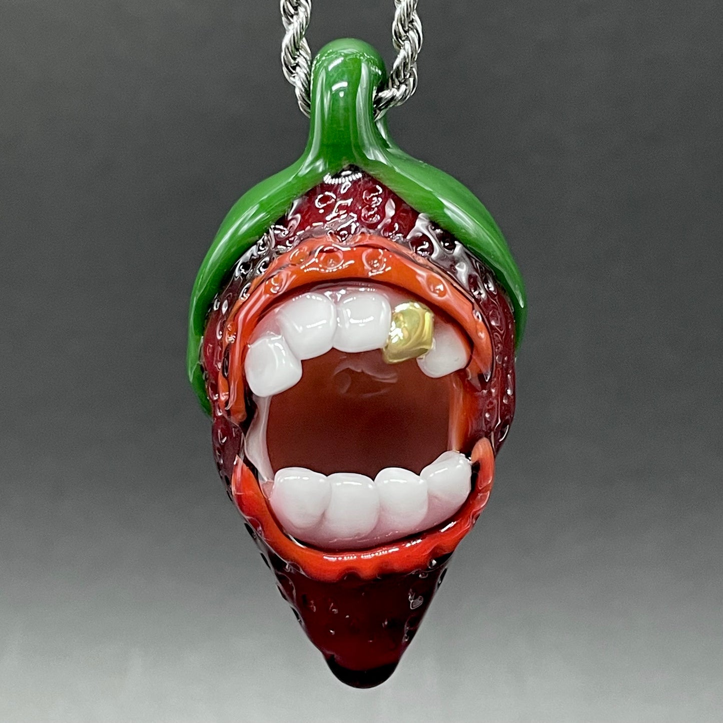Close-up of Screaming strawberry glass pendant - handcrafted glass