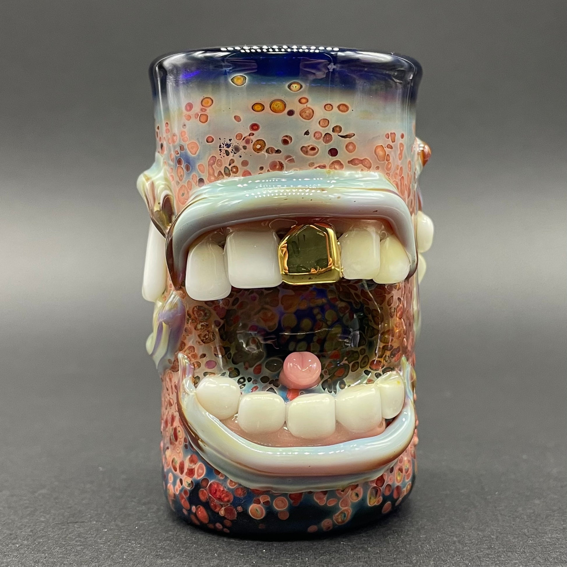 Close-up of Too many mouths to feed shot glass - handcrafted glass