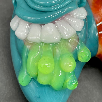 Two Headaches Are Better Than One handblown glass pendant - teal cyclops head with white teeth and green slime fused with red cyclops head with pink tongue, silver rope chain - Leviathan Glass