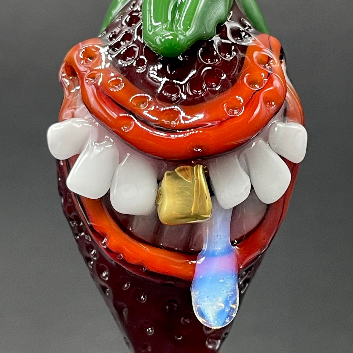 Close-up of Toothy strawberry pendant - handcrafted glass