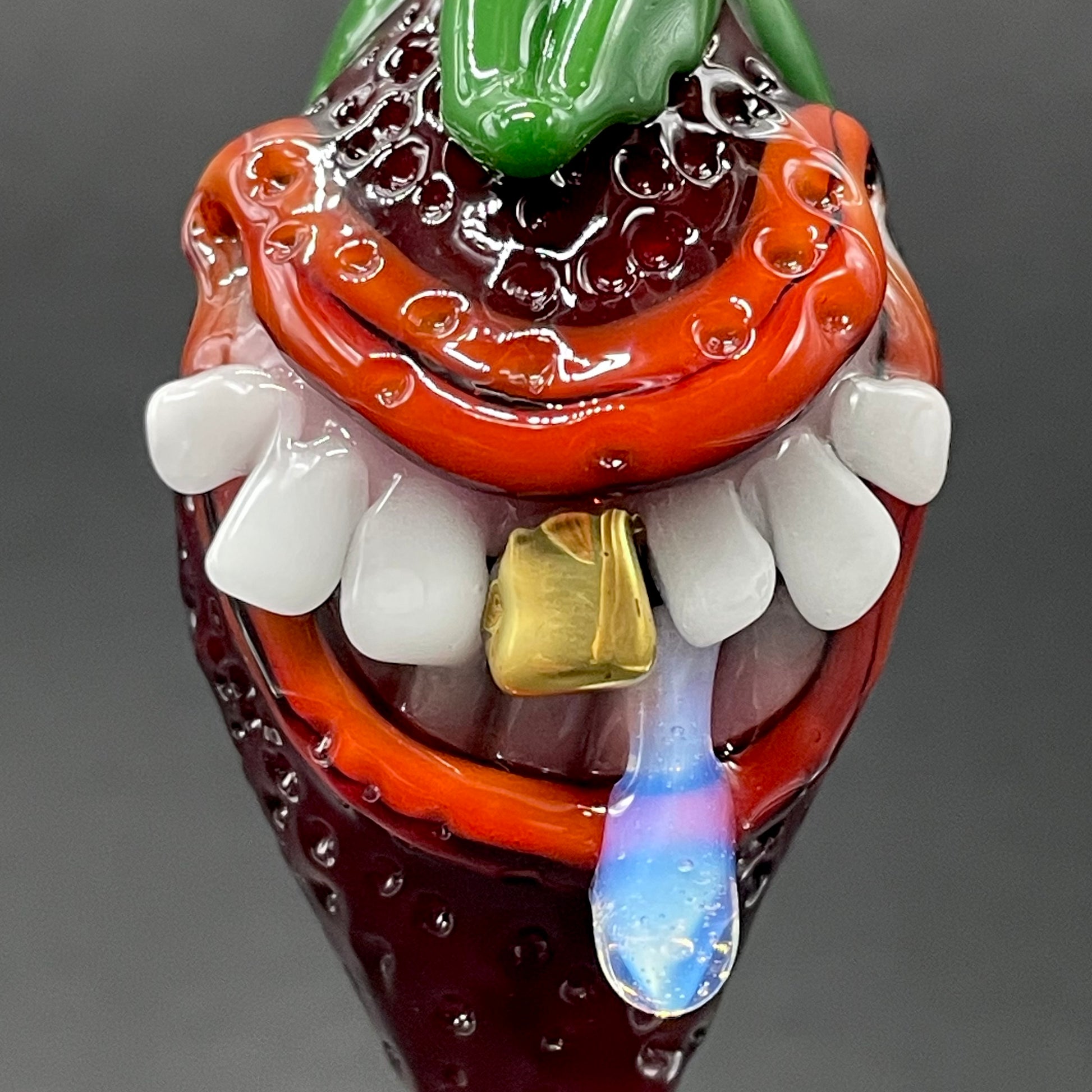 Close-up of Toothy strawberry pendant - handcrafted glass