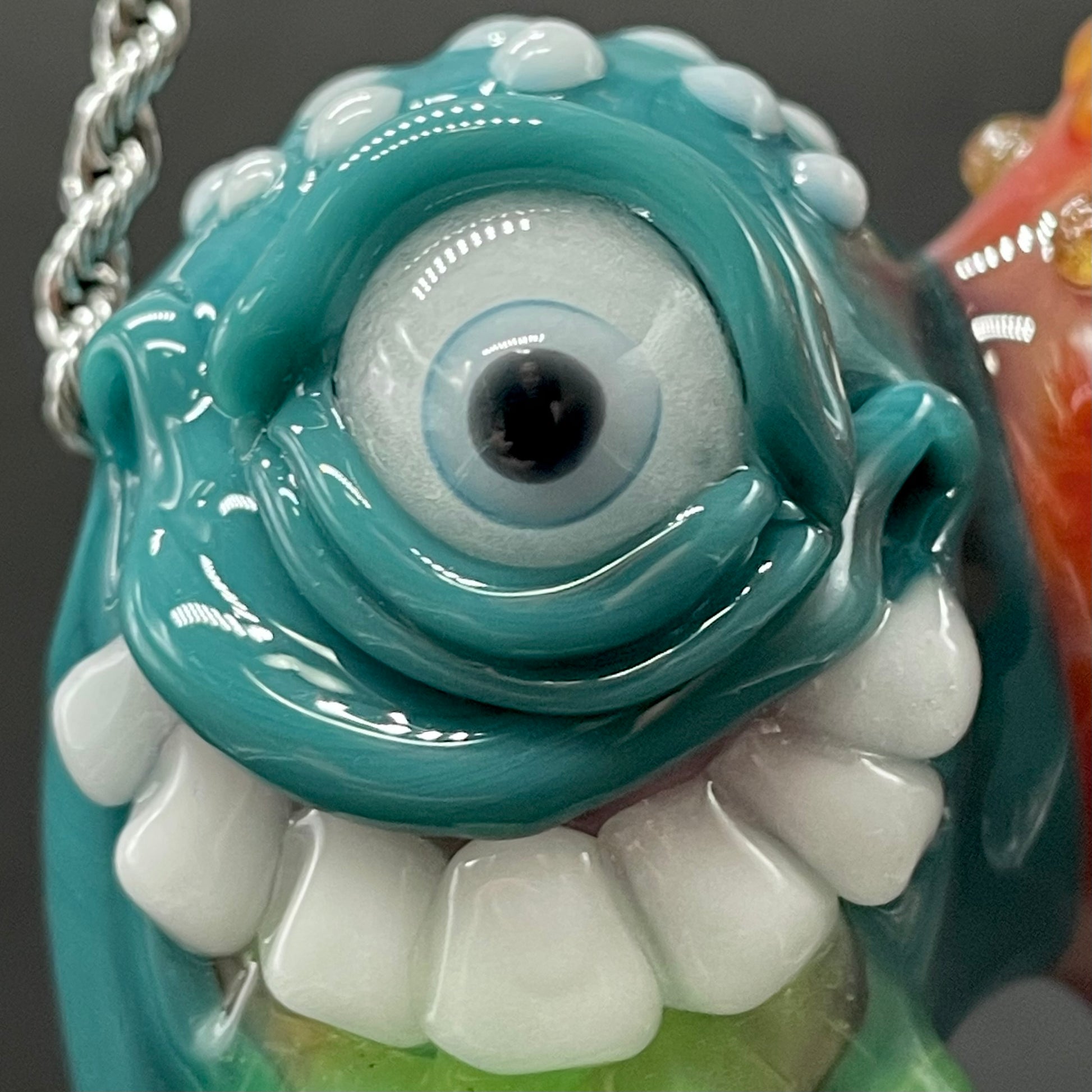 Two Headaches Are Better Than One handblown glass pendant - teal cyclops head with white teeth and green slime fused with red cyclops head with pink tongue, silver rope chain - Leviathan Glass