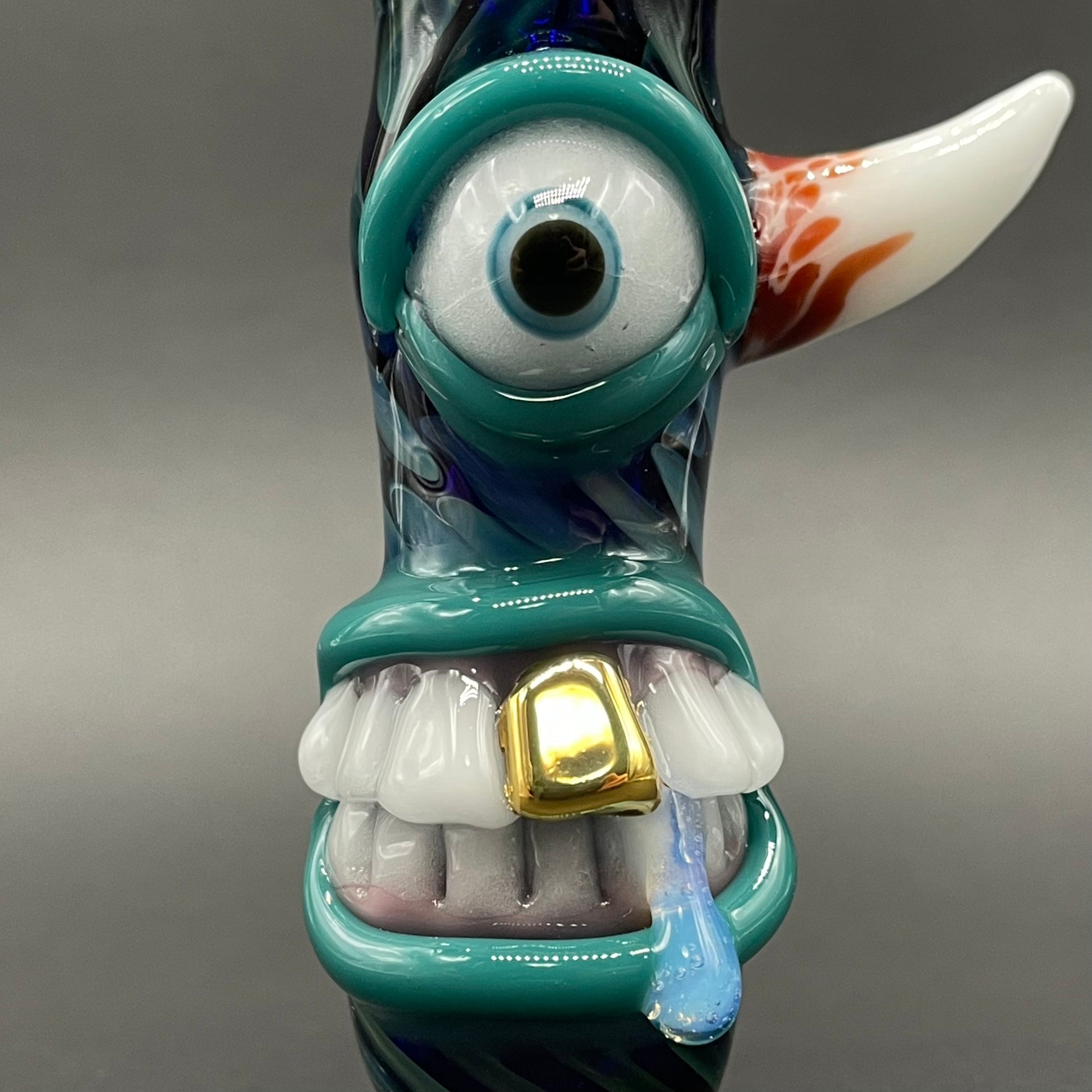 Close-up of Gold fumed cyclops Chillum - handcrafted glass