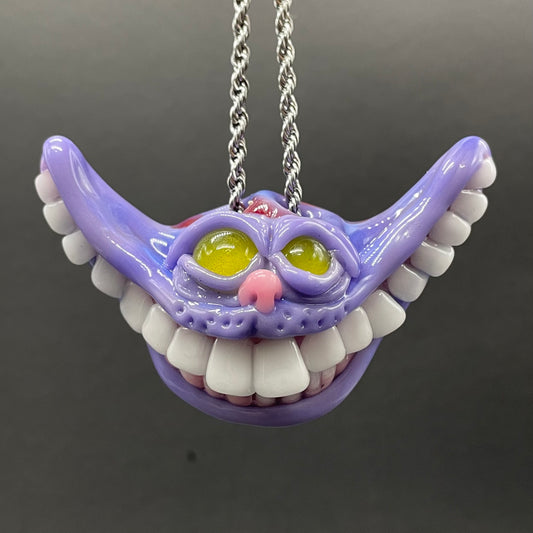 Grinning Cheshire cat glass pendant