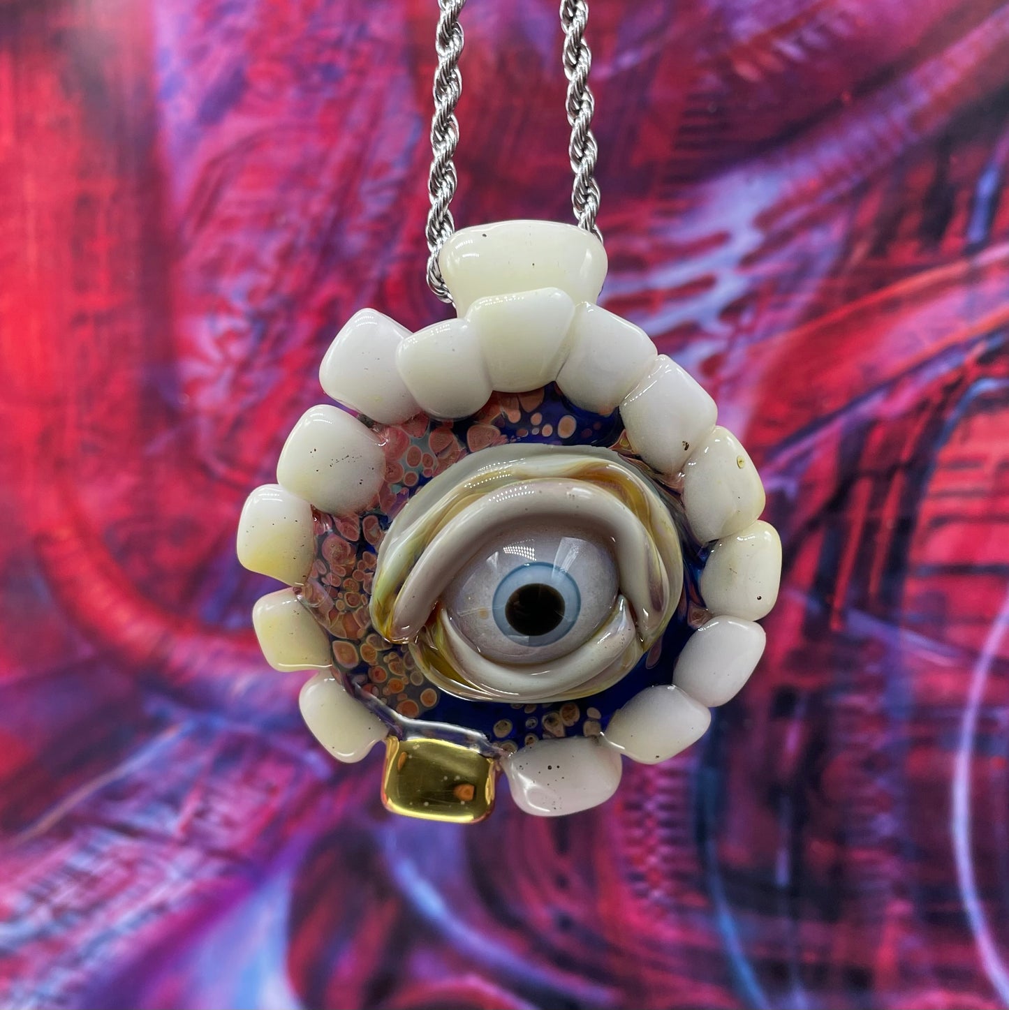 Unidentified Object Delta handblown glass pendant - circular disc ringed with ivory teeth, blue iris eye center, eyelid, gold tooth accent, silver rope chain - Leviathan Glass