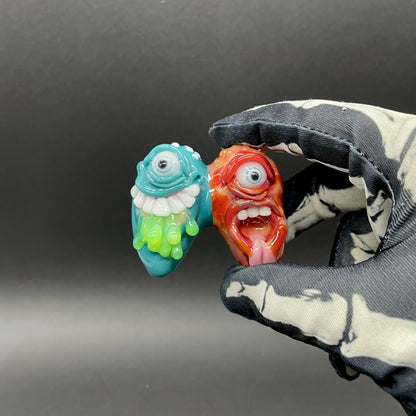 Two Headaches Are Better Than One handblown glass pendant - teal cyclops head with white teeth and green slime fused with red cyclops head with pink tongue, silver rope chain - Leviathan Glass