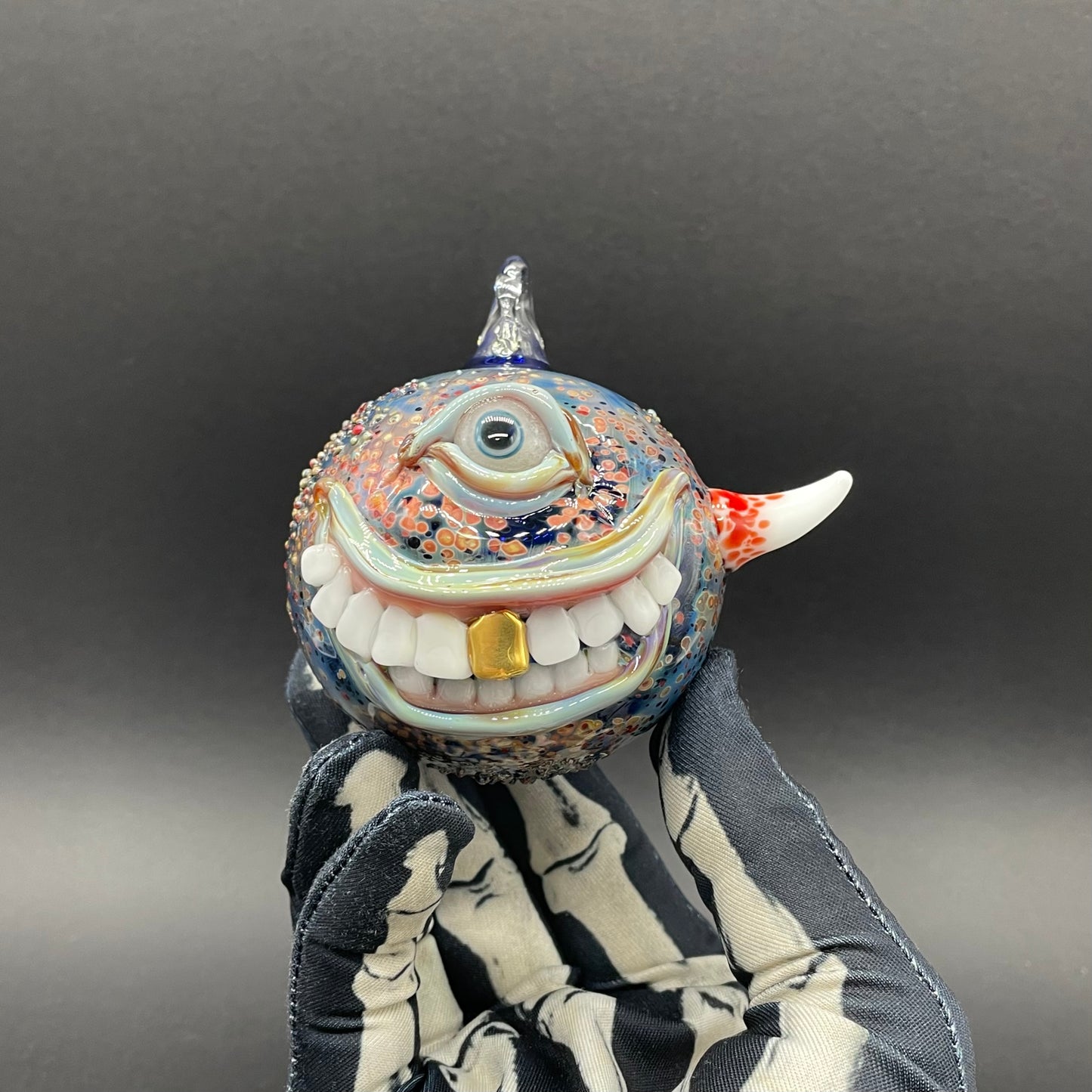 Close-up of Smiling cyclops ornament - handcrafted glass