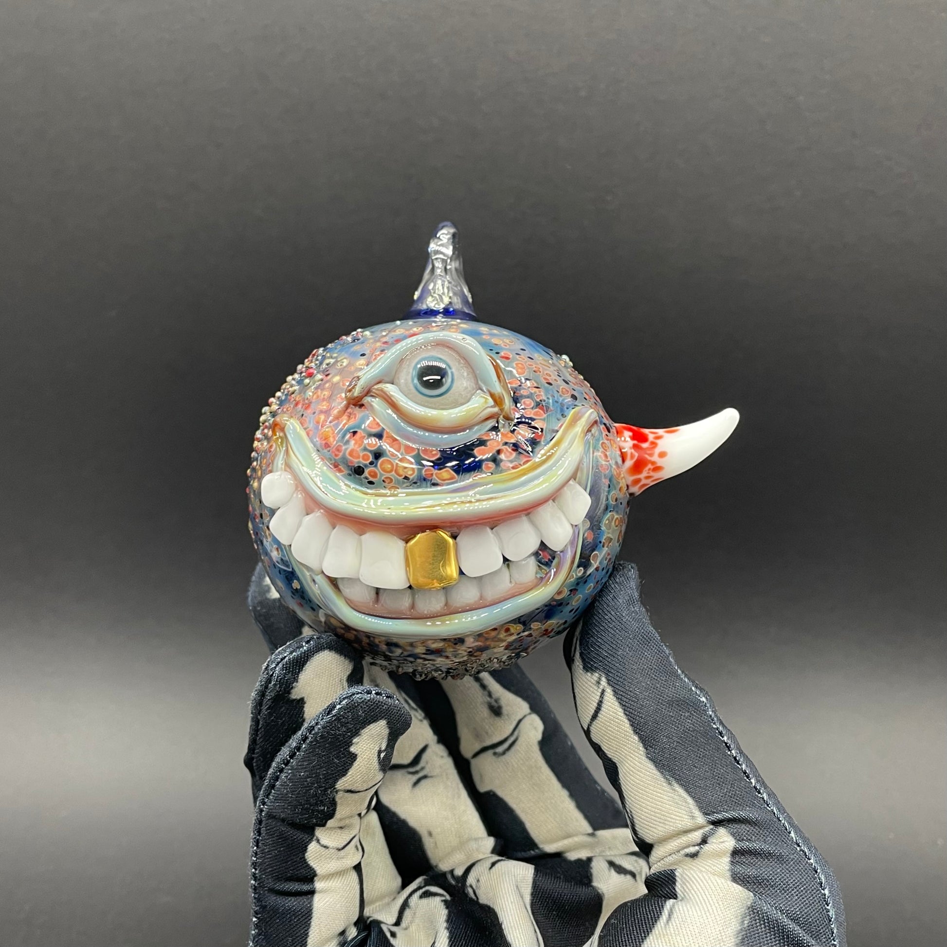 Close-up of Smiling cyclops ornament - handcrafted glass