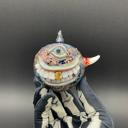 Close-up of Smiling cyclops ornament - handcrafted glass