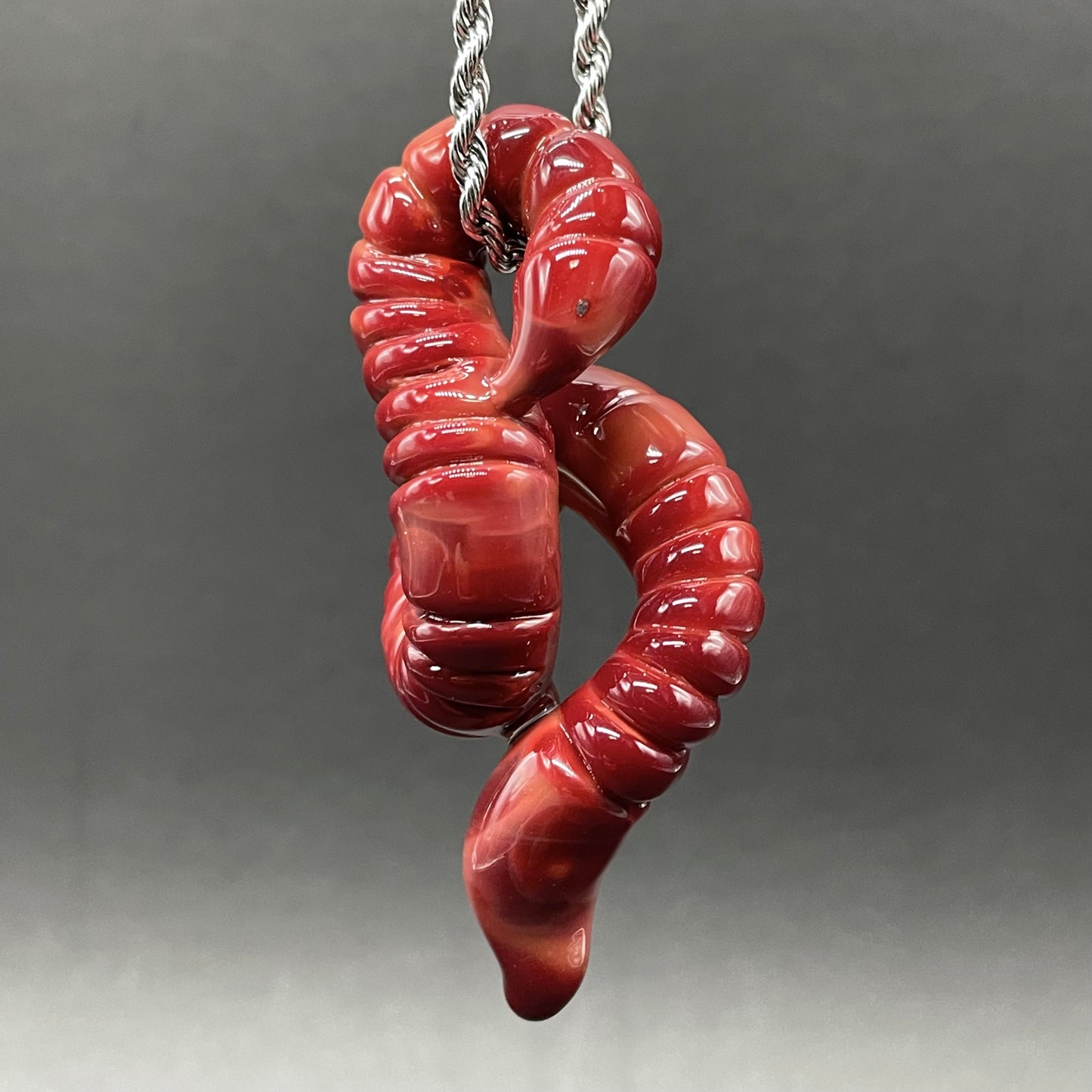 Close-up of glass earthworm pendant - handcrafted glass