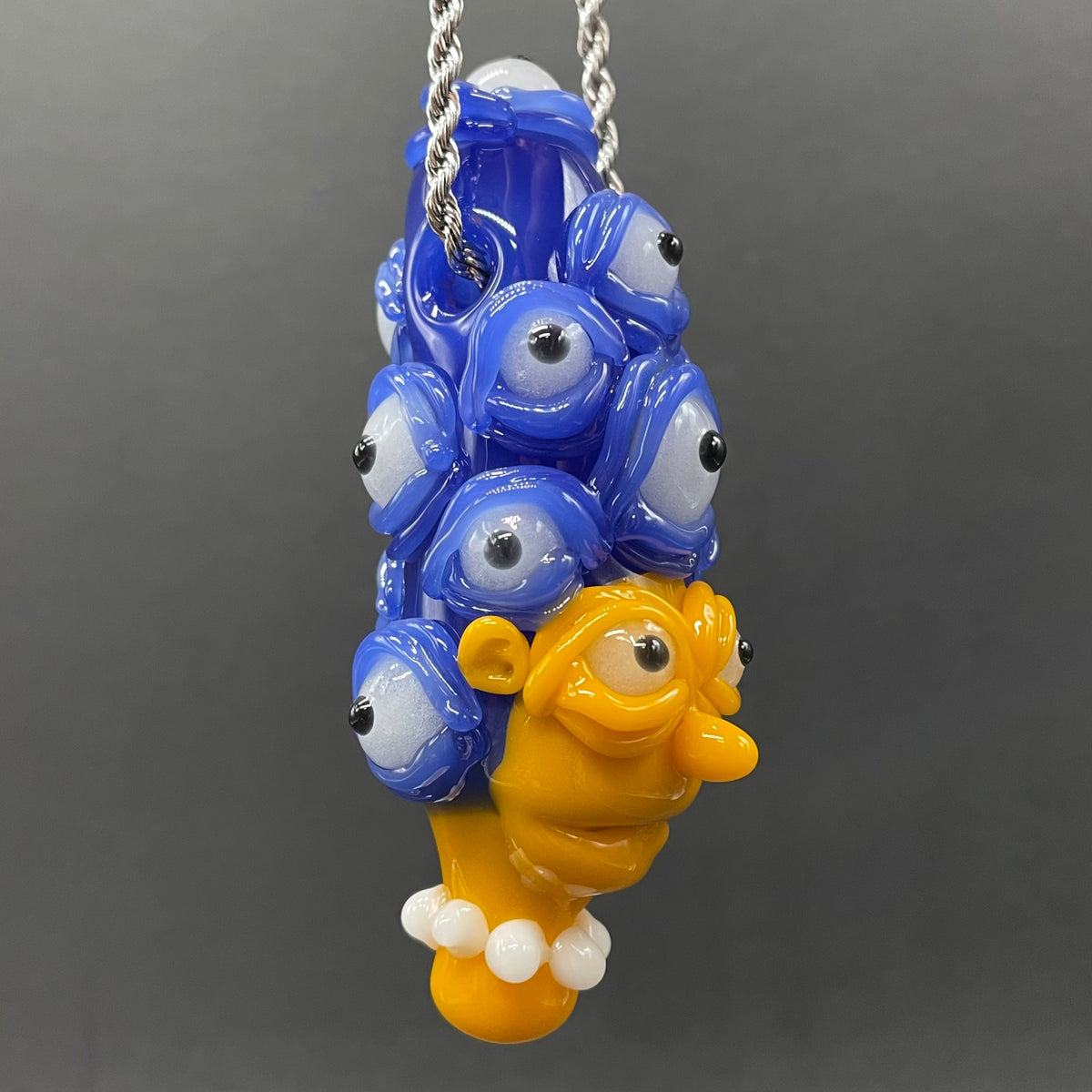 Marge Simpson Mutant handblown glass pendant - yellow Marge Simpson face with towering stack of blue cyclops creatures forming her hair, white pearl beads, silver rope chain - Leviathan Glass