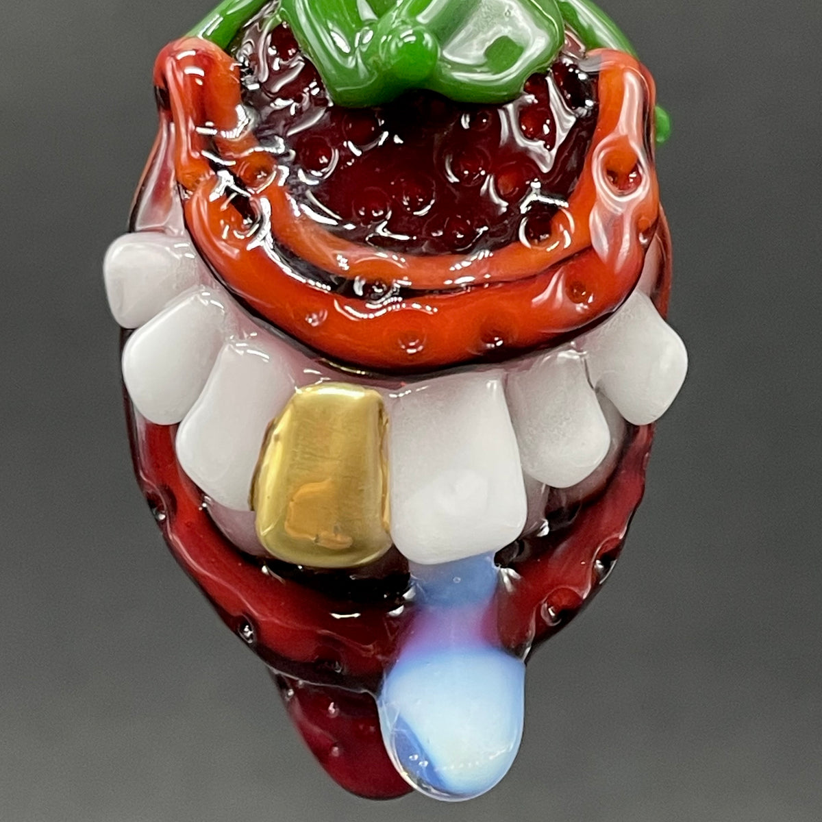 Close-up of Toothy strawberry pendant - handcrafted glass