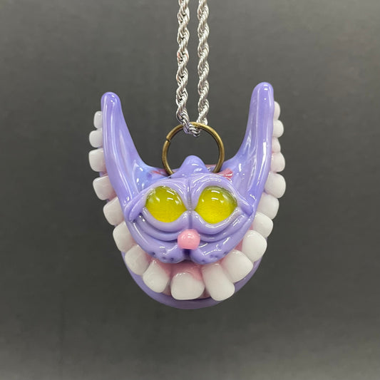 Grinning Cheshire cat glass pendant