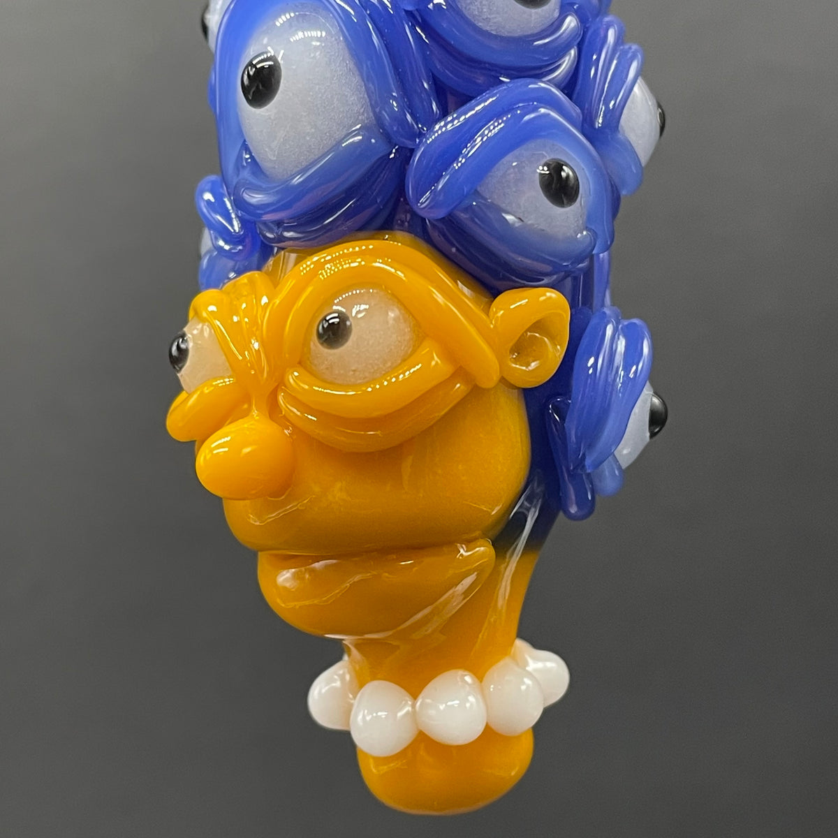 Marge Simpson Mutant handblown glass pendant - yellow Marge Simpson face with towering stack of blue cyclops creatures forming her hair, white pearl beads, silver rope chain - Leviathan Glass
