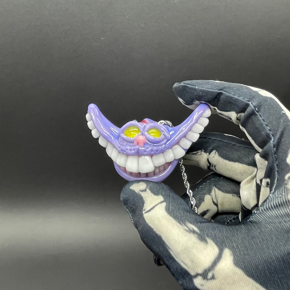 Grinning Cheshire cat glass pendant