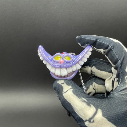 Grinning Cheshire cat glass pendant