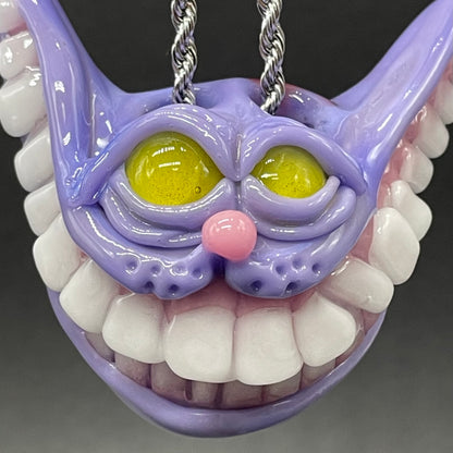 Grinning Cheshire cat glass pendant