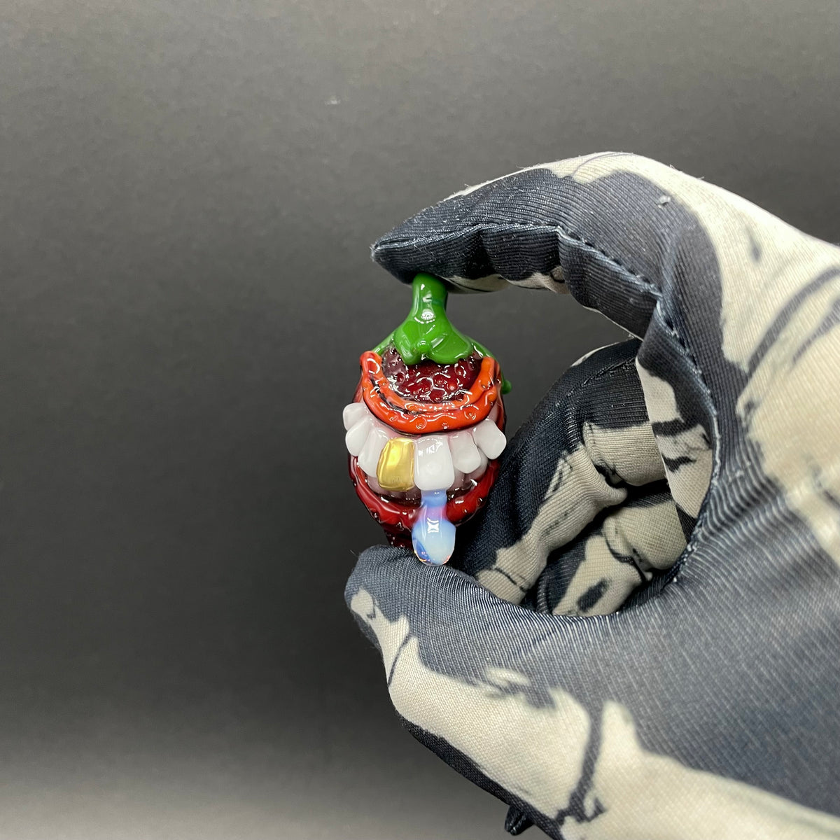Close-up of Toothy strawberry pendant - handcrafted glass