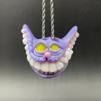 Grinning Cheshire cat glass pendant