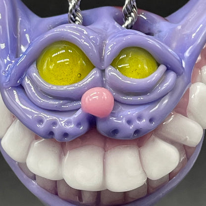 Grinning Cheshire cat glass pendant