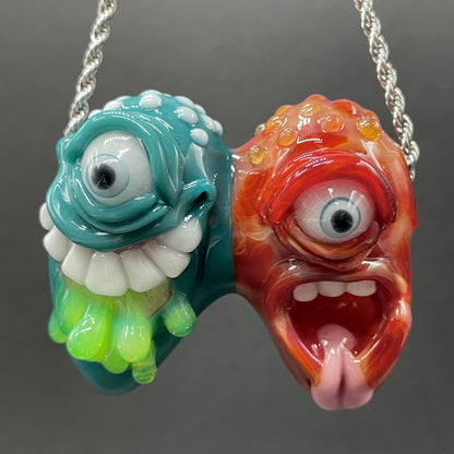 Two Headaches Are Better Than One handblown glass pendant - teal cyclops head with white teeth and green slime fused with red cyclops head with pink tongue, silver rope chain - Leviathan Glass