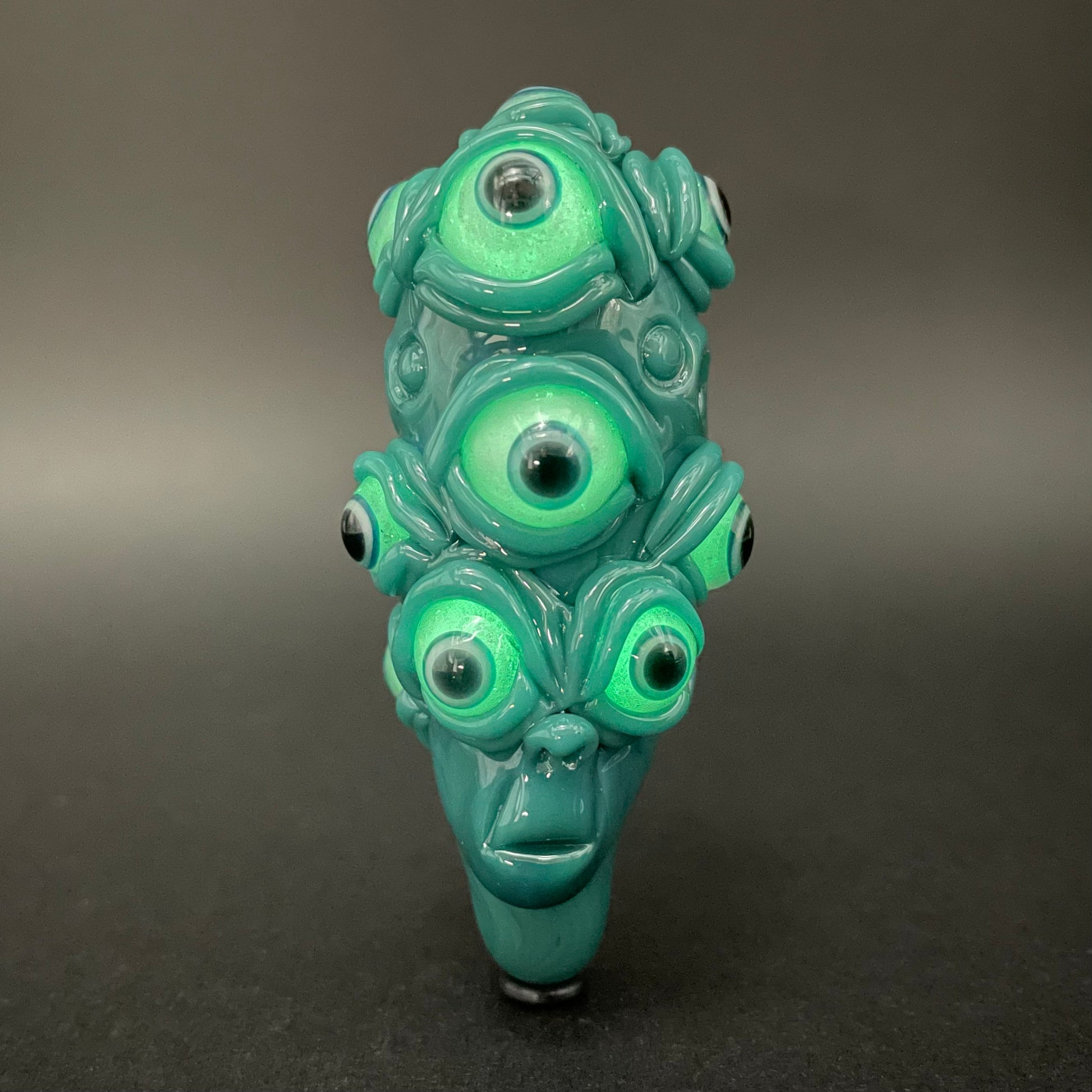 Close-up of The Never-Blinking One glass effigy pendant - handcrafted glass