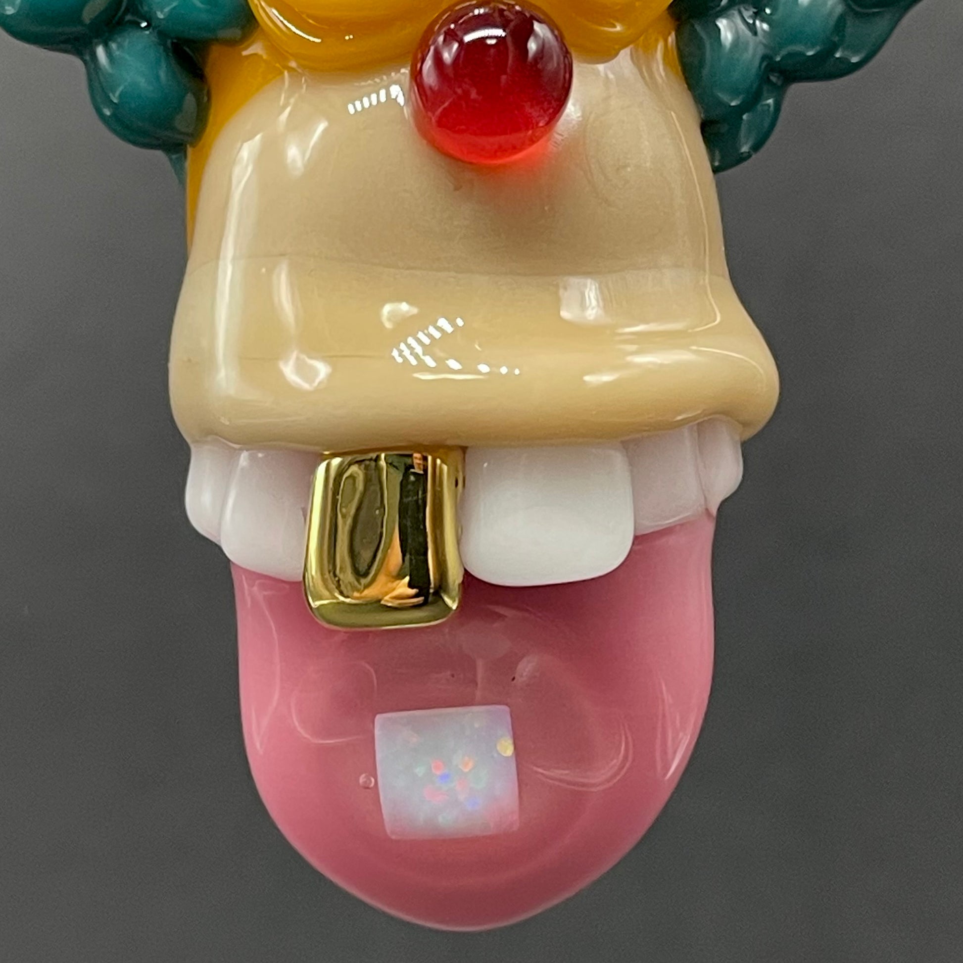 Close-up of Krusty the clown glass pendant with opal tab - handcrafted glass
