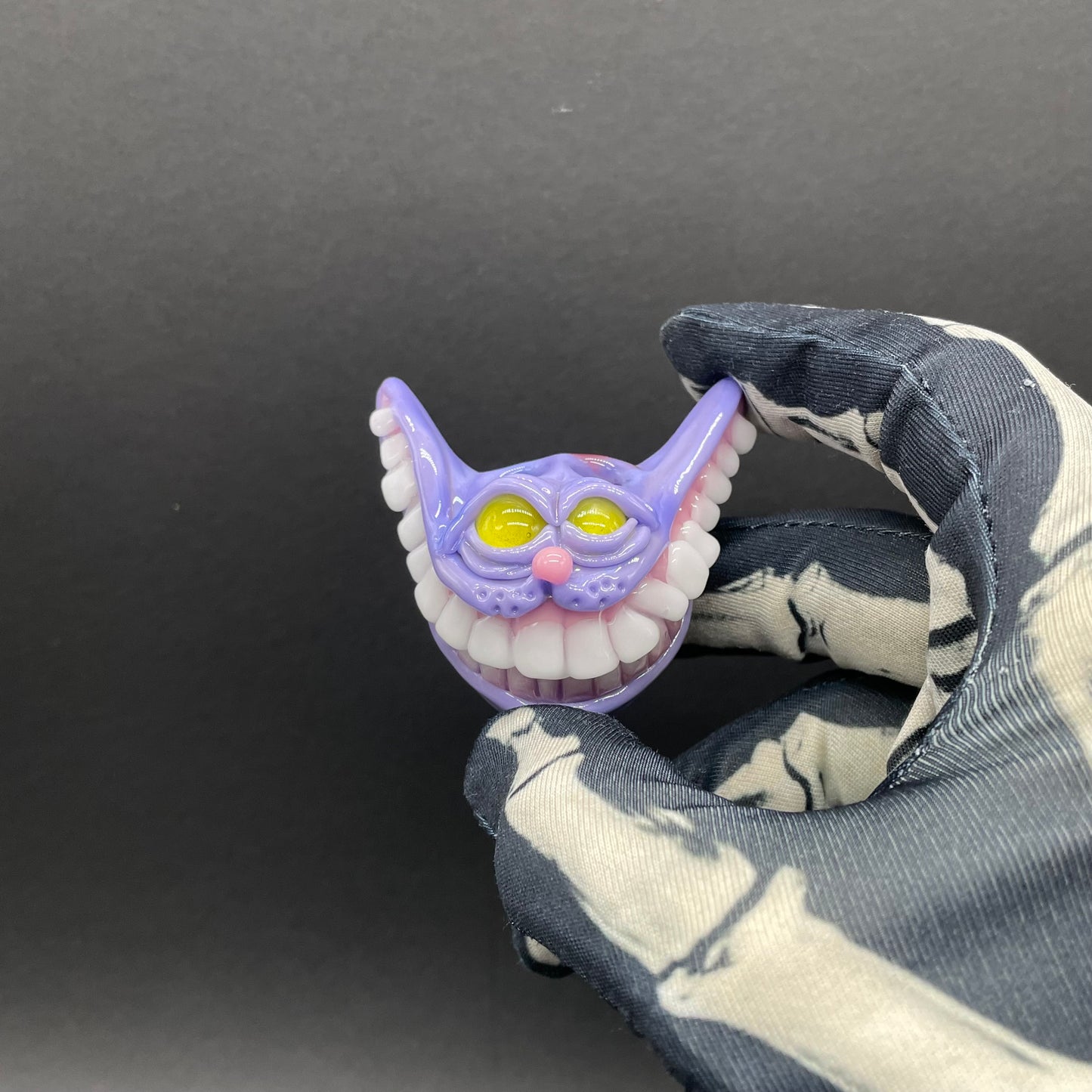 Grinning Cheshire cat glass pendant