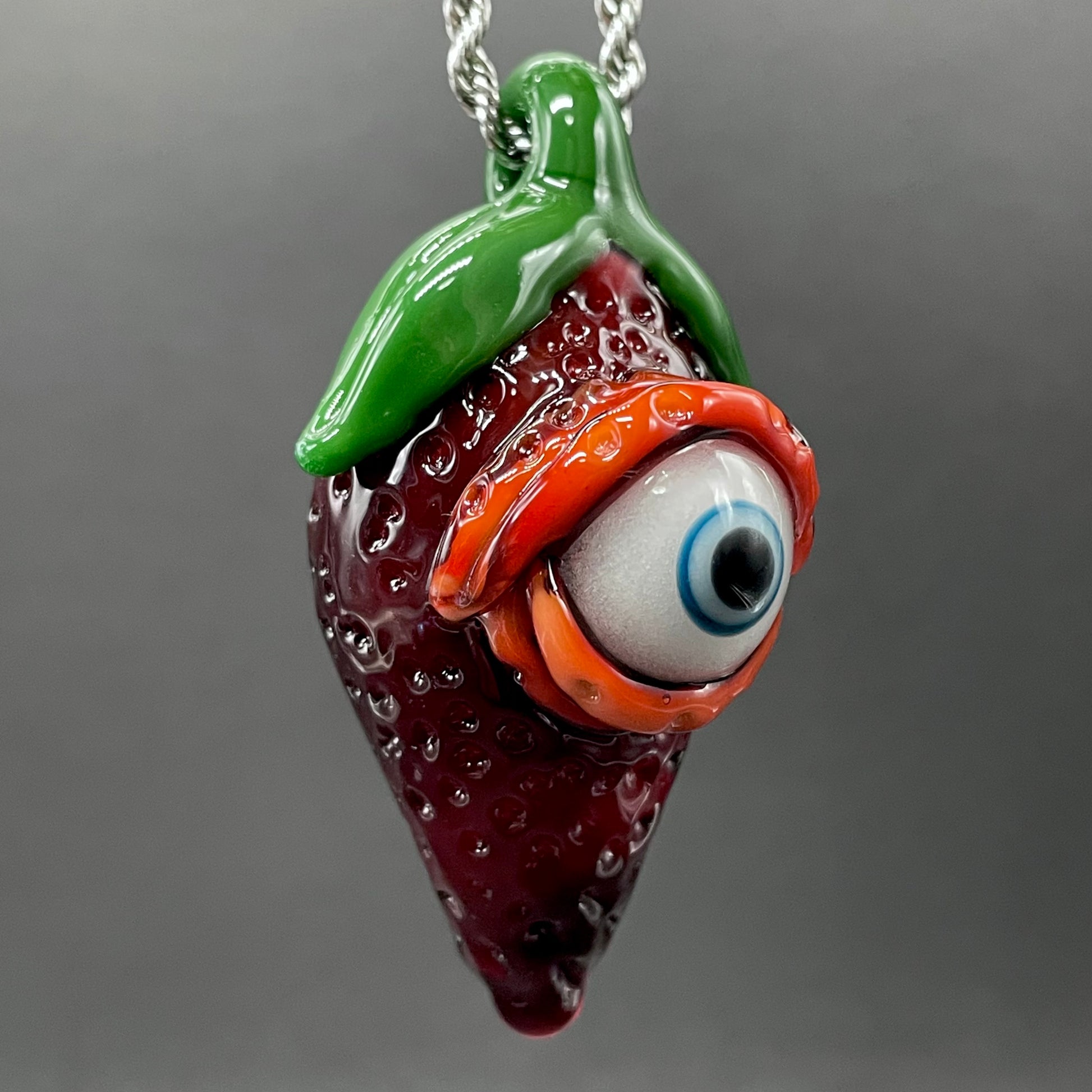 Close-up of Cyclops strawberry pendant - handcrafted glass