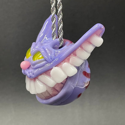 Grinning Cheshire cat glass pendant