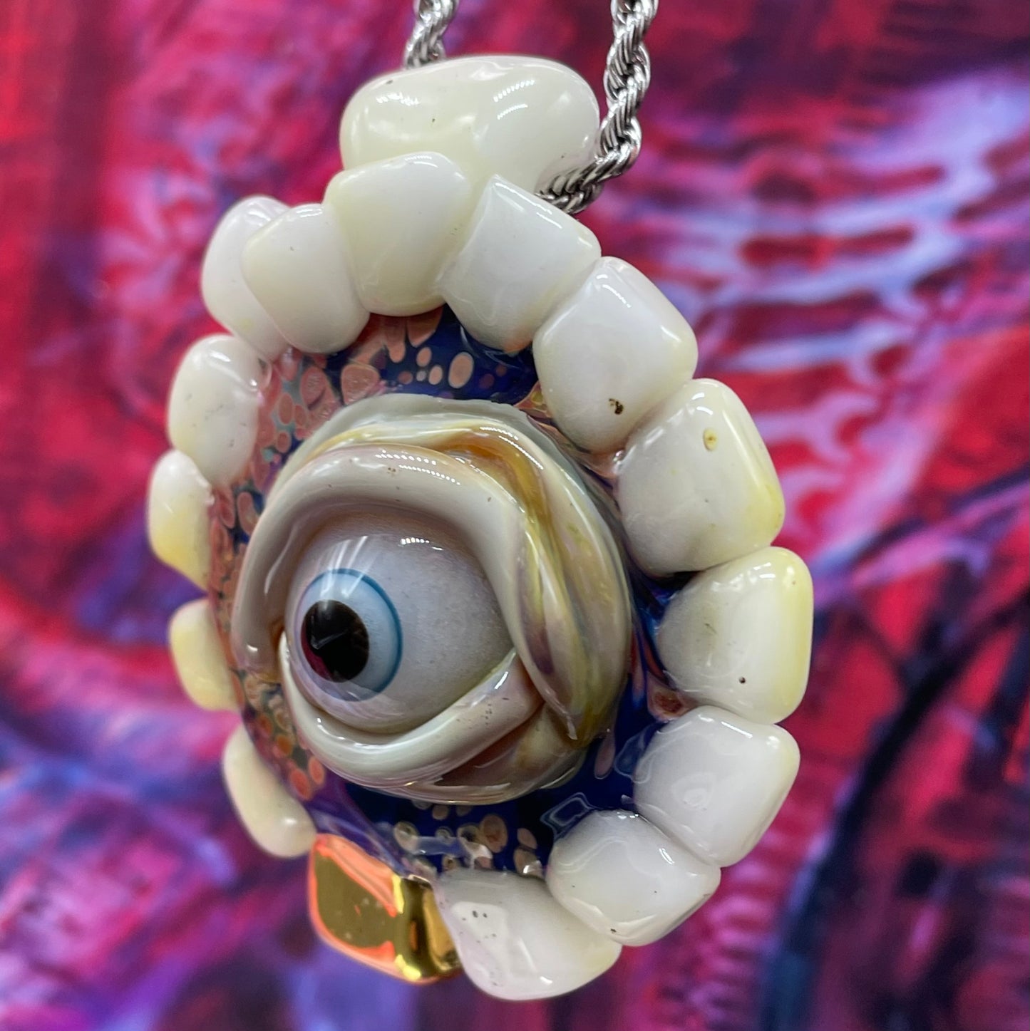 Unidentified Object Delta handblown glass pendant - circular disc ringed with ivory teeth, blue iris eye center, eyelid, gold tooth accent, silver rope chain - Leviathan Glass