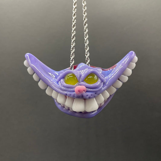 Grinning Cheshire cat glass pendant