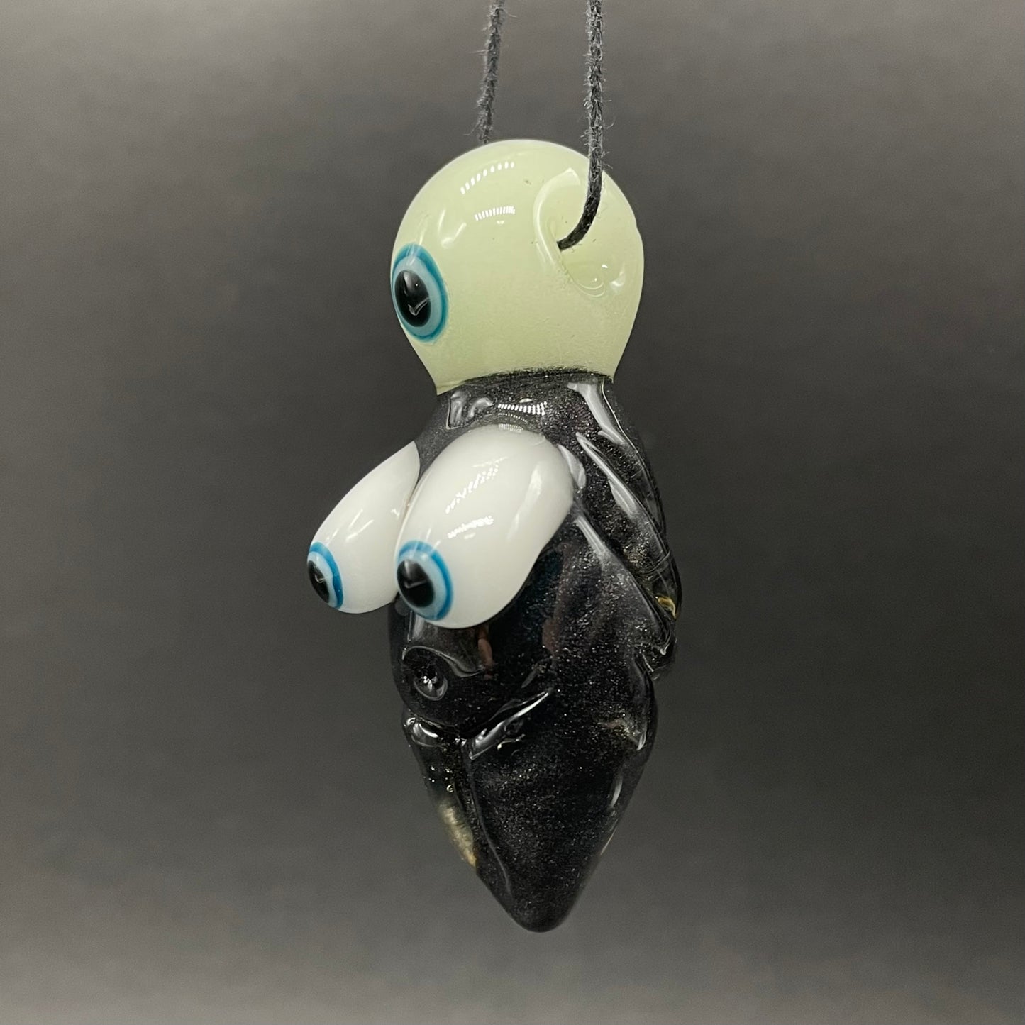 Close-up of Black light reactive fertility pendant - handcrafted glass
