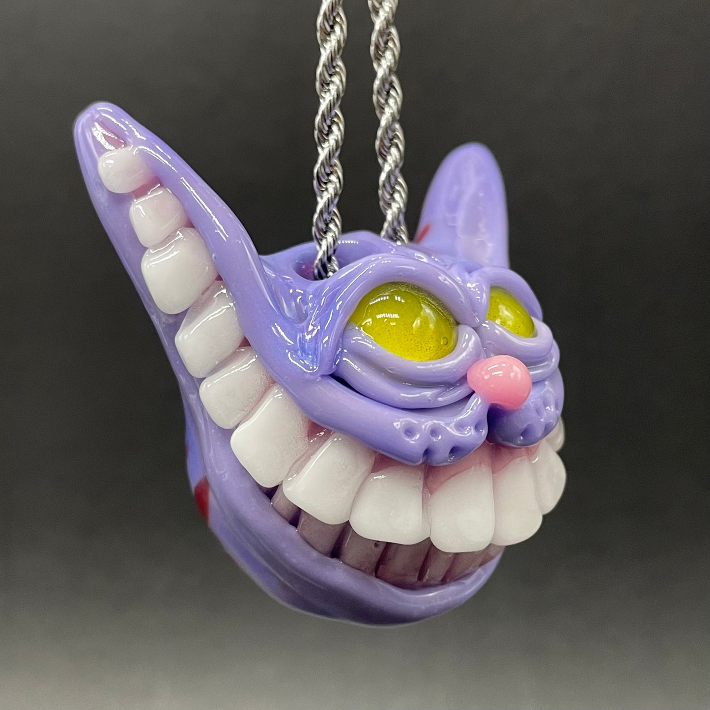 Grinning Cheshire cat glass pendant