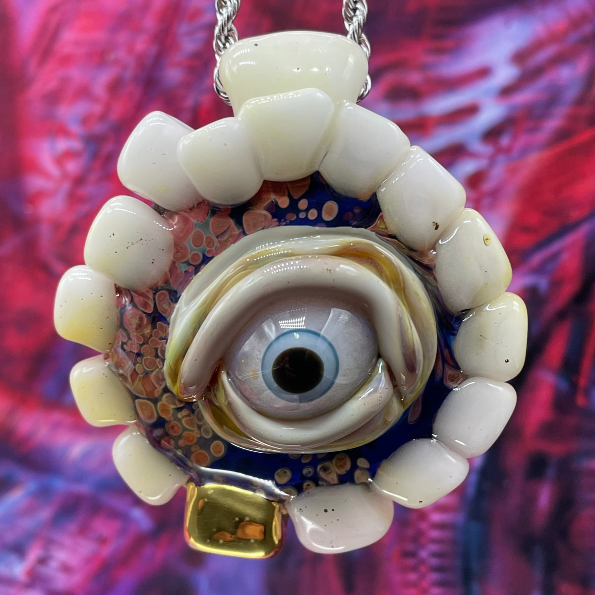 Unidentified Object Delta handblown glass pendant - circular disc ringed with ivory teeth, blue iris eye center, eyelid, gold tooth accent, silver rope chain - Leviathan Glass