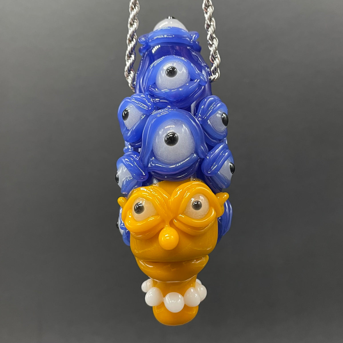 Marge Simpson Mutant handblown glass pendant - yellow Marge Simpson face with towering stack of blue cyclops creatures forming her hair, white pearl beads, silver rope chain - Leviathan Glass